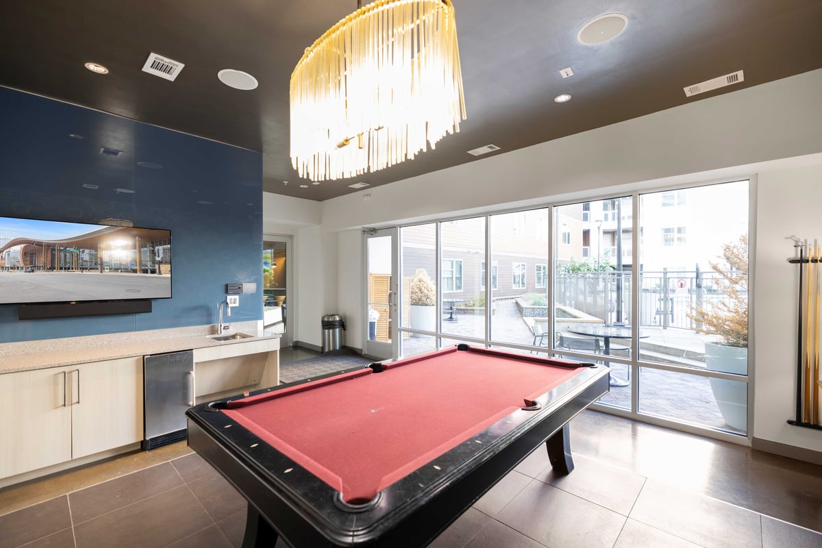 Common area lounge with pool table and kitchen.